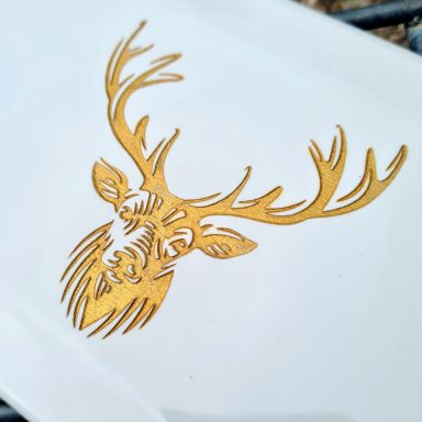 A white ceramic tile engraved with a Stag's head